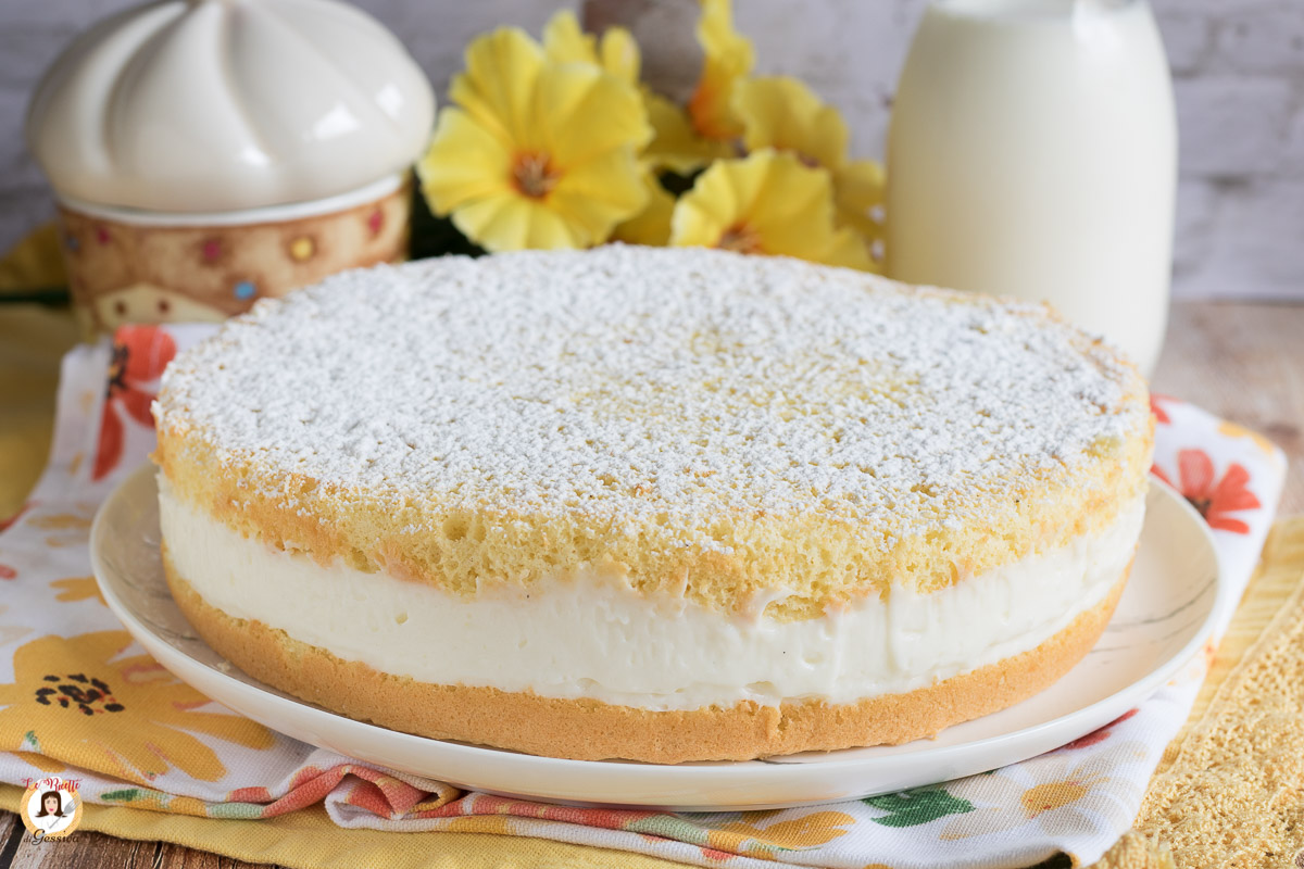 Una torta soffice con ripieno di crema e zucchero a velo, servita con eleganza su un piatto.