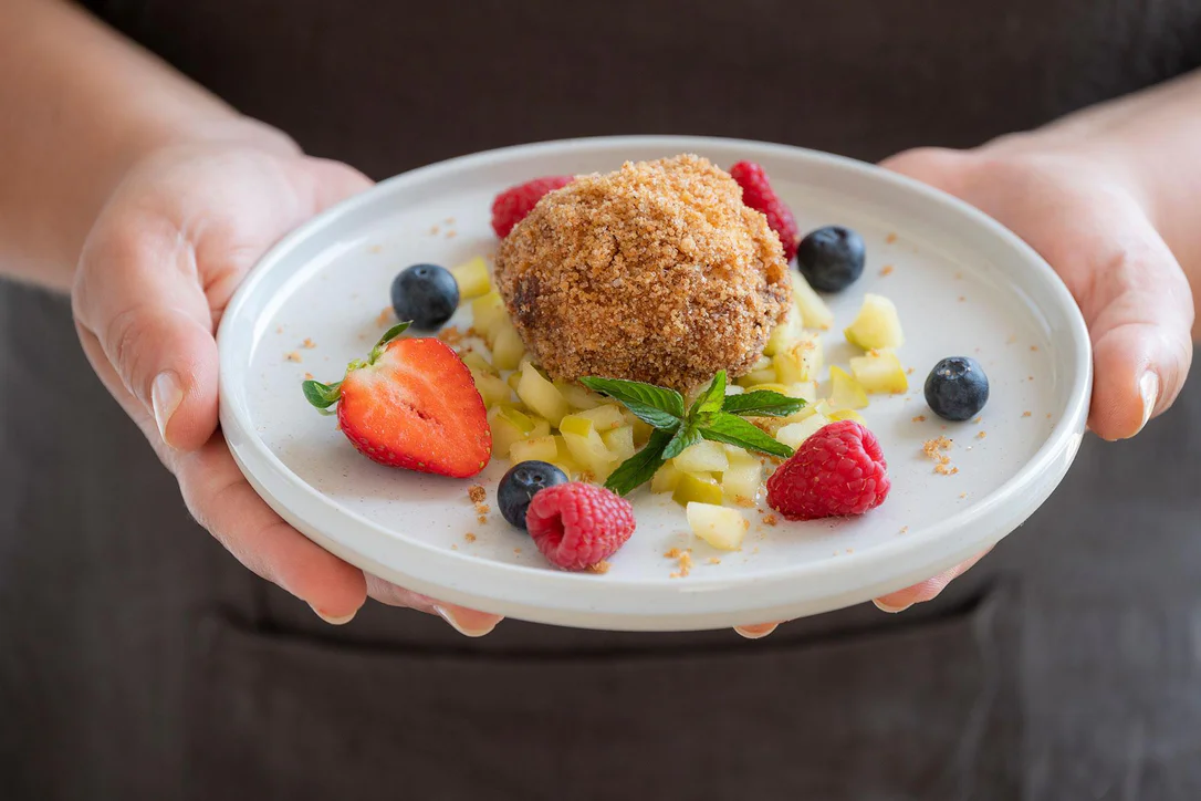 Nougat dumplings served on a bed of South Tyrolean apple ragout with fresh berries