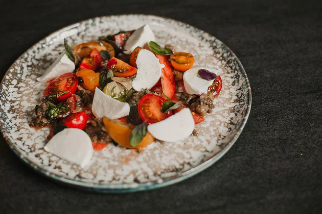 Tomato salad with aubergine, mozzarella and basil