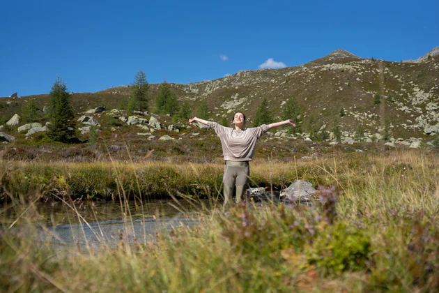 Una ragazza si gode il sole, l'aria pura e il panorama in una bella giornata in Valle Aurina