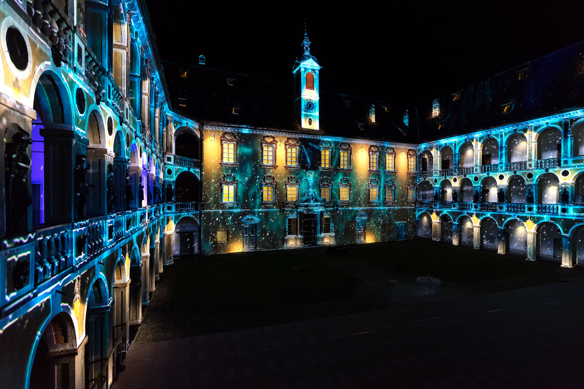 Pohled na svítící, vznášející se mořské živočichy nad náměstím Domplatz v Brixenu při festivalu světla Lightfestival Brixen