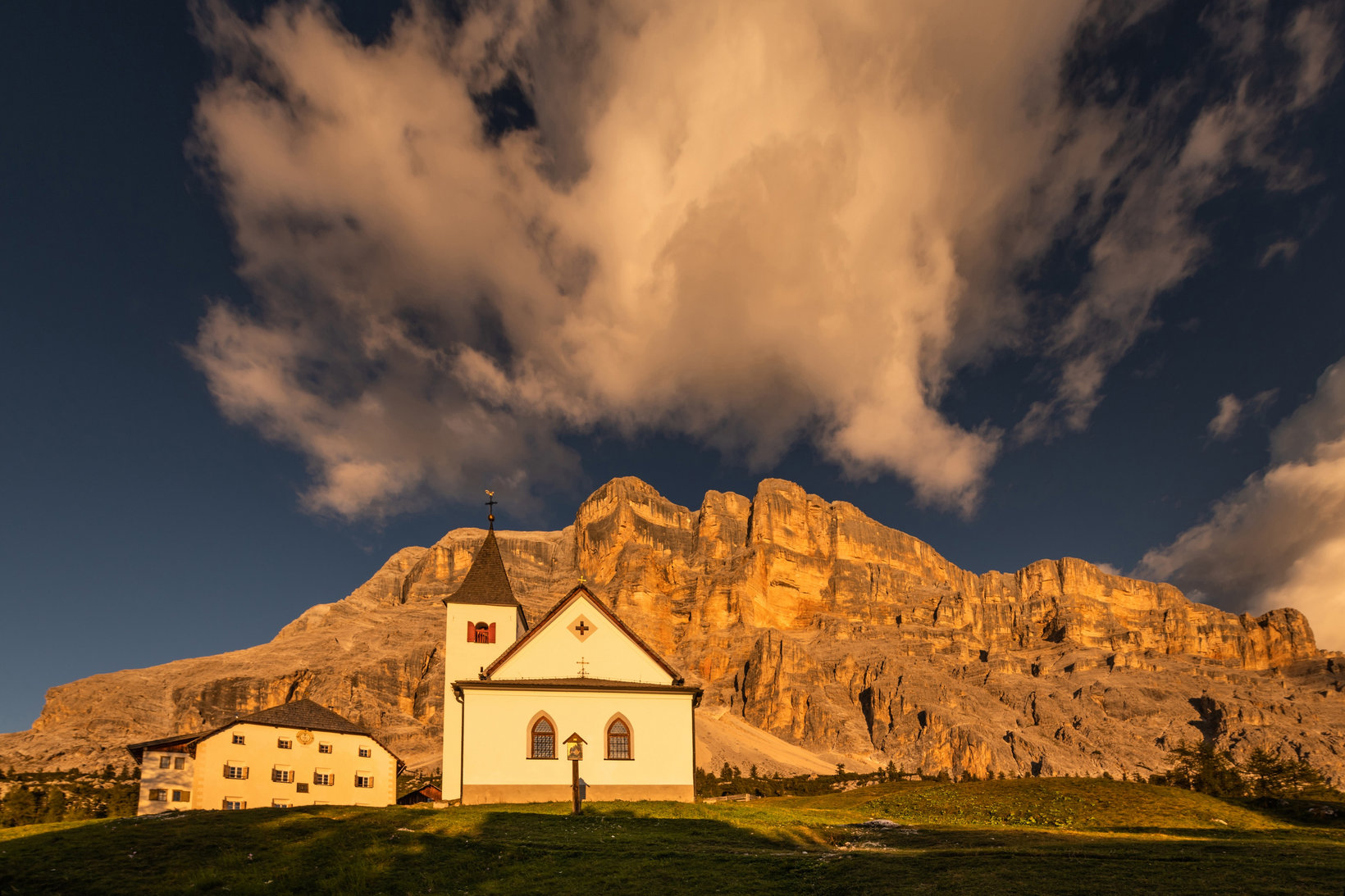 Sasso di Santa Croce al tramonto con una piccola chiesa in primo piano
