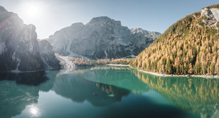 Pohled na jezero Pragser Wildsee, obklopené horami a podzimním jehličnatým lesem