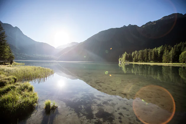 Soleil se reflétant dans les eaux du lac Antholzer See.