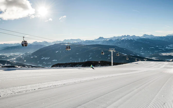 Impianto di risalita e piste innevate con un panorama montano sullo sfondo a Rio Pusteria