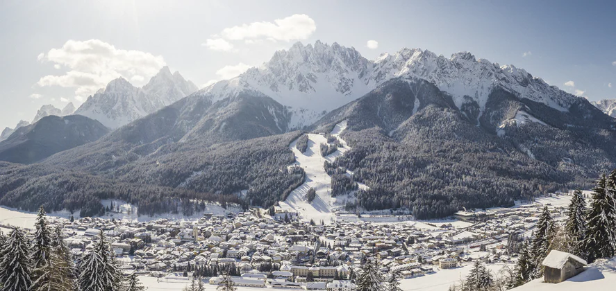 Vista su San Candido contornata da un paesaggio montano e boschivo