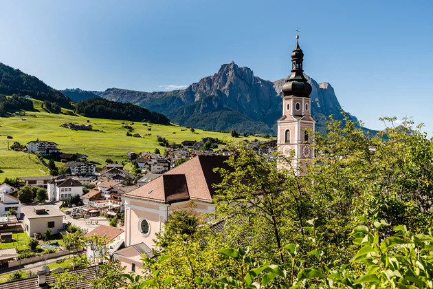 Vista dal Colle che sovrasta Castelrotto sulla chiesa parrocchiale con il suo imponente campanile, sullo sfondo lo Sciliar