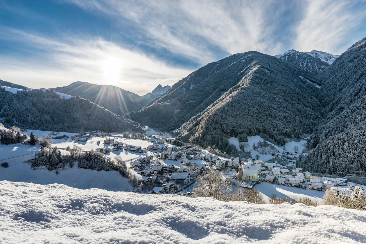 Vista sulla località di Luson e i prati verdi che lo circondano. In secondo piano il panorama montano e boschivo della valle