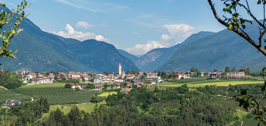 View of Natz-Schabs surrounded by green meadows, fields and mountains.