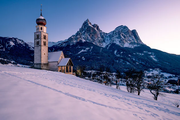 Vista sul paese di Siusi allo Sciliar, sullo sfondo ampi boschi e l'omonimo massiccio dello Sciliar che si erge da esso