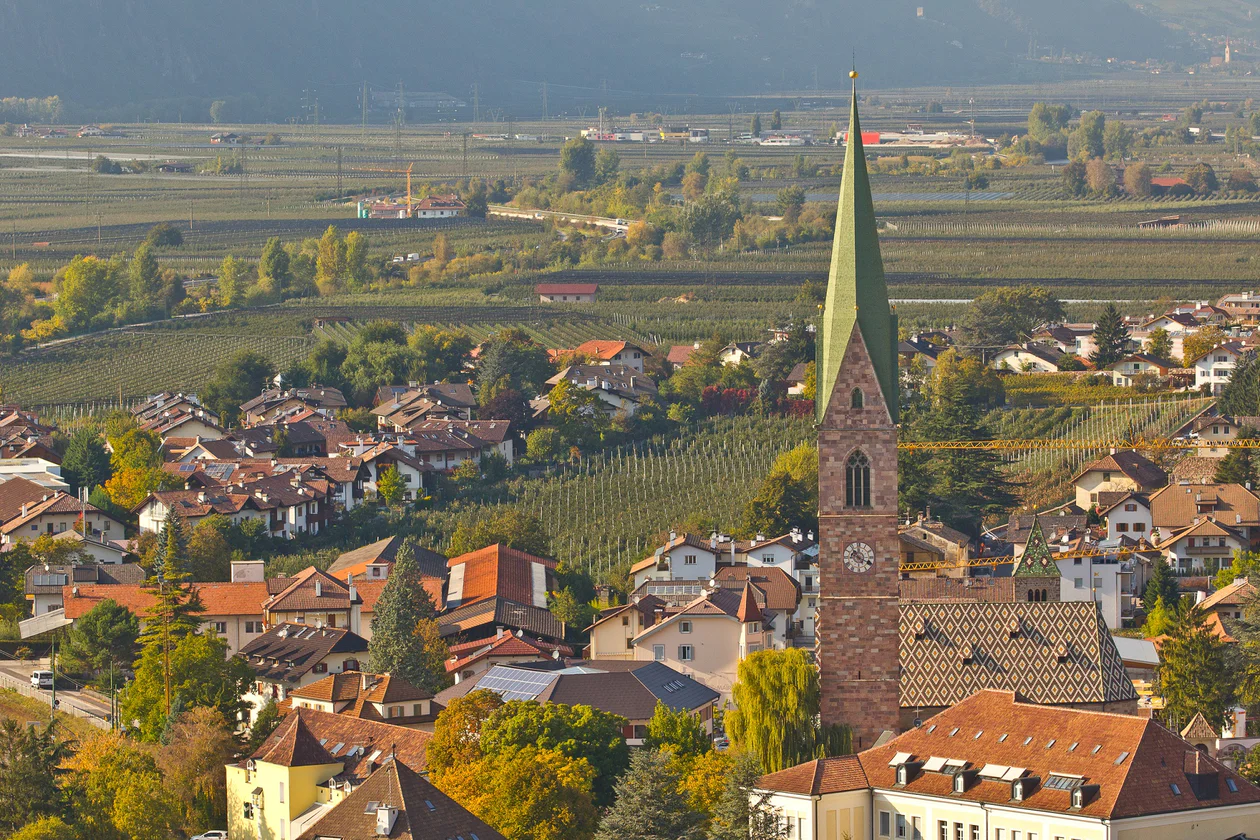 Vista aerea sui vigneti che circondano Terlano e il campanile del paese in secondo piano