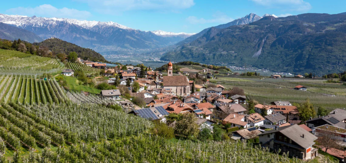 Vista panoramica su una chiesa in primo piano e la vallata verdeggiante in secondo piano