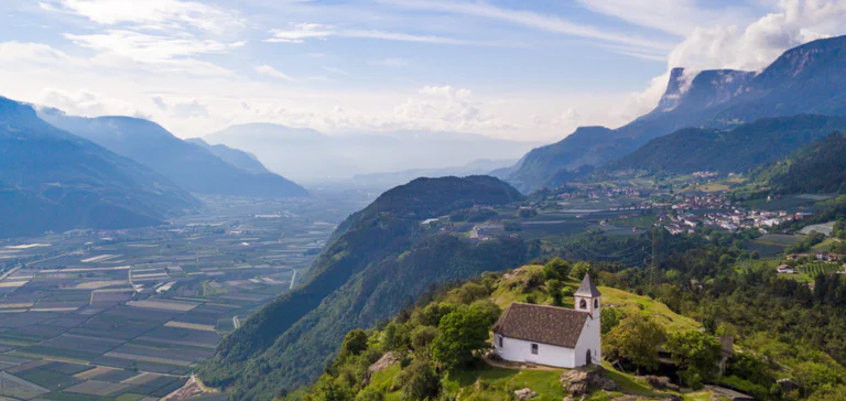 Vista panoramica su una chiesa in primo piano e la vallata verdeggiante in secondo piano
