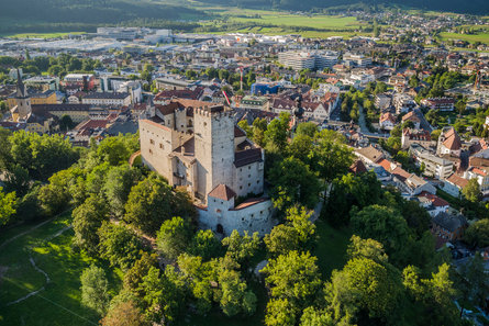 Vista del Castello di Brunico circondato da alberi e il centro abitato sullo sfondo