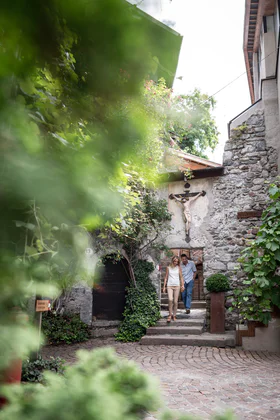 Una coppia scende le scale che entra nel centro storico di Chiusa venendo dalla rocca di Sabiona