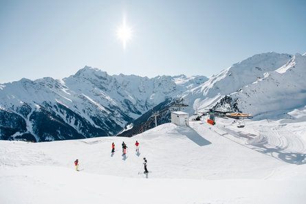 Sommige mensen op ski's voor een skilift met een grenzeloos panorama achter zich