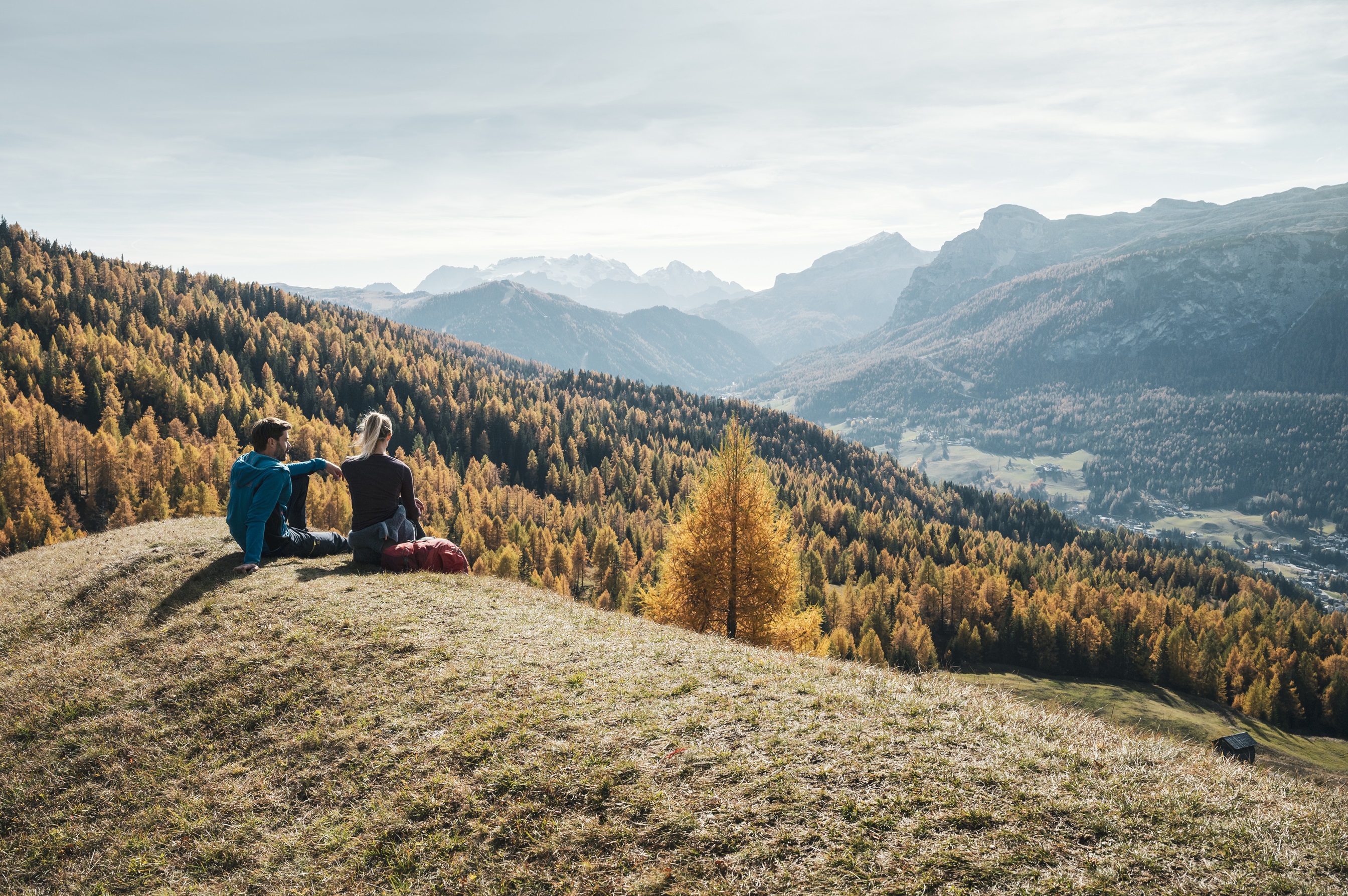 Zwei Personen genießen das Panorama in Alta Badia im Herbst