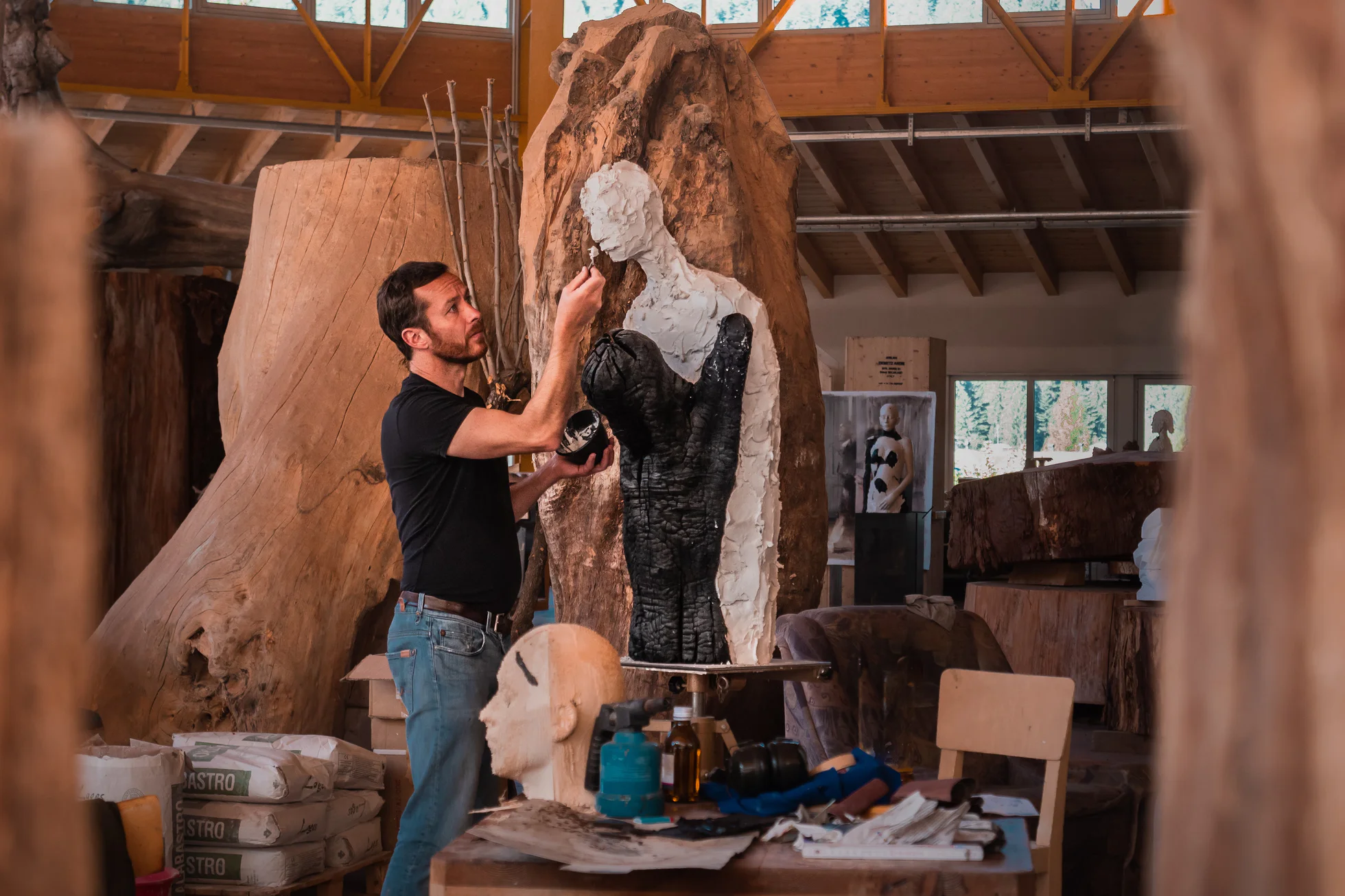 Sculptor Aron Demetz works on a piece of art in his studio.