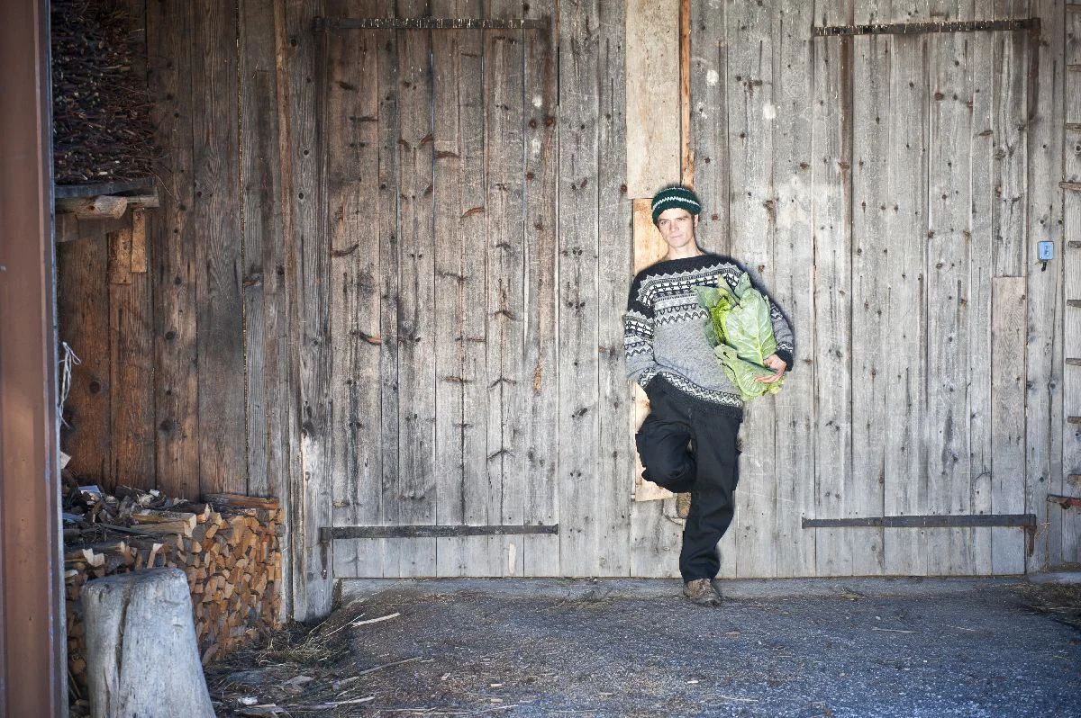 Harald Gasser appoggiato alla porta del fienile