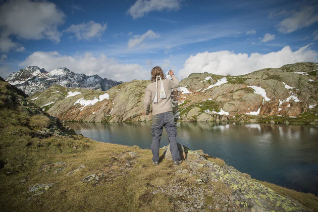 Bodypainter Johannes Stötter bei der Arbeit vor einem Südtiroler Bergsee.