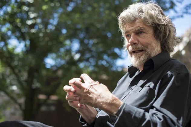 Himalaista, fundator muzeów i autor książek Reinhold Messner żywo gestykuluje podczas rozmowy.