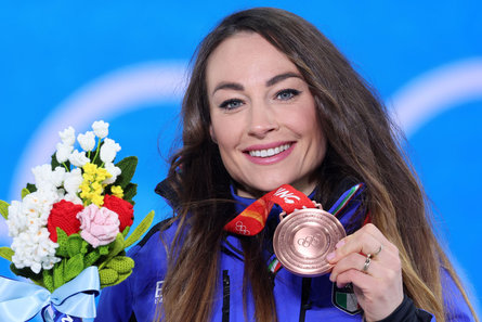 La biathlète Dorothea Wierer montre fièrement au photographe l’une des médailles de bronze qu’elle a remportées aux Jeux olympiques.