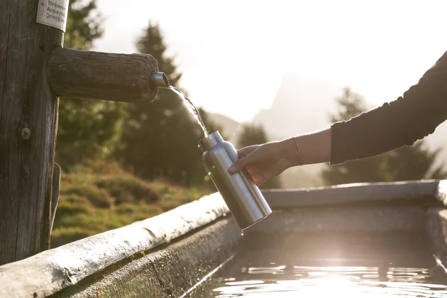 Wasserauffüllen am Brunnen