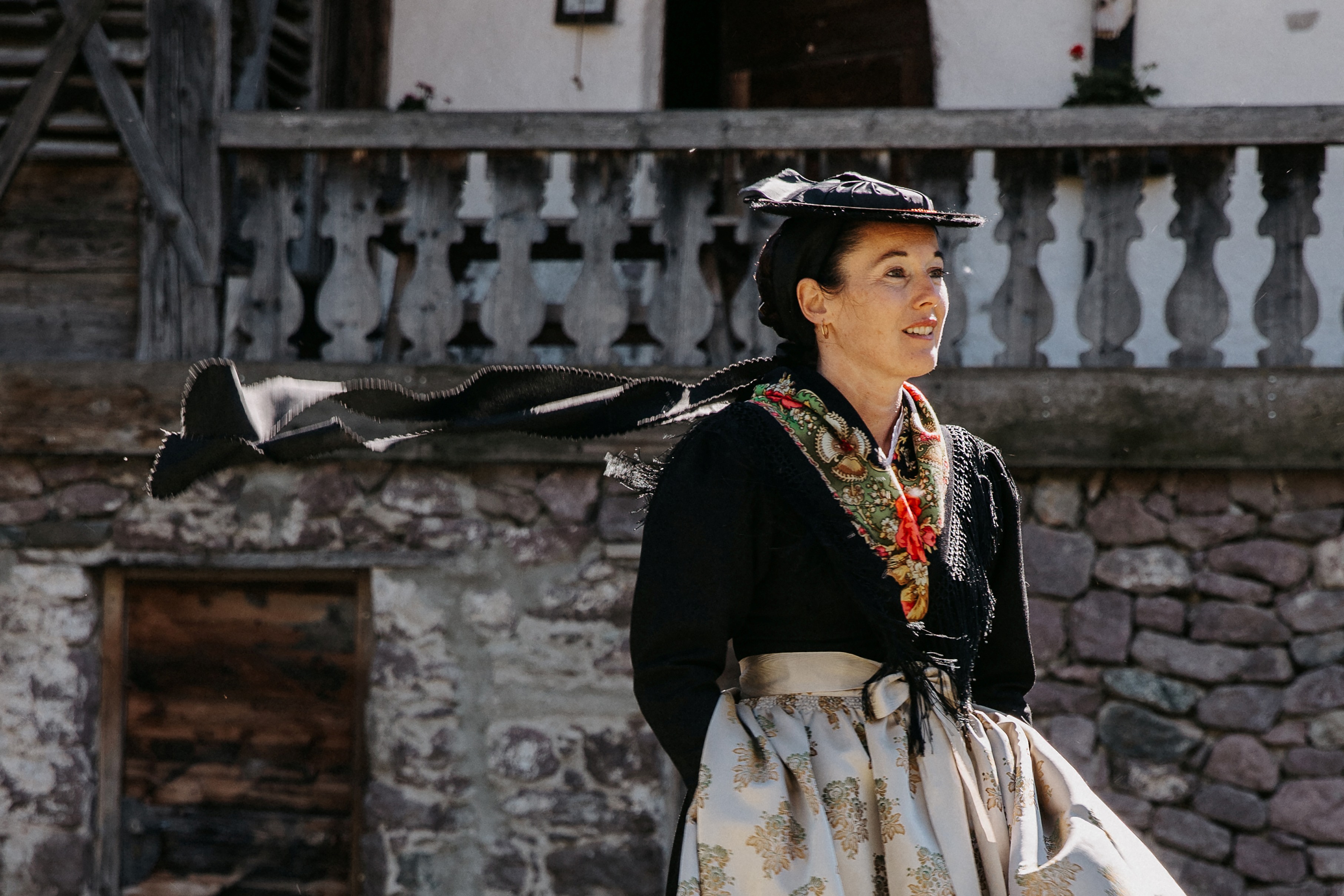 Una donna con il tradizionale costume della Val Sarentino davanti a un antico maso
