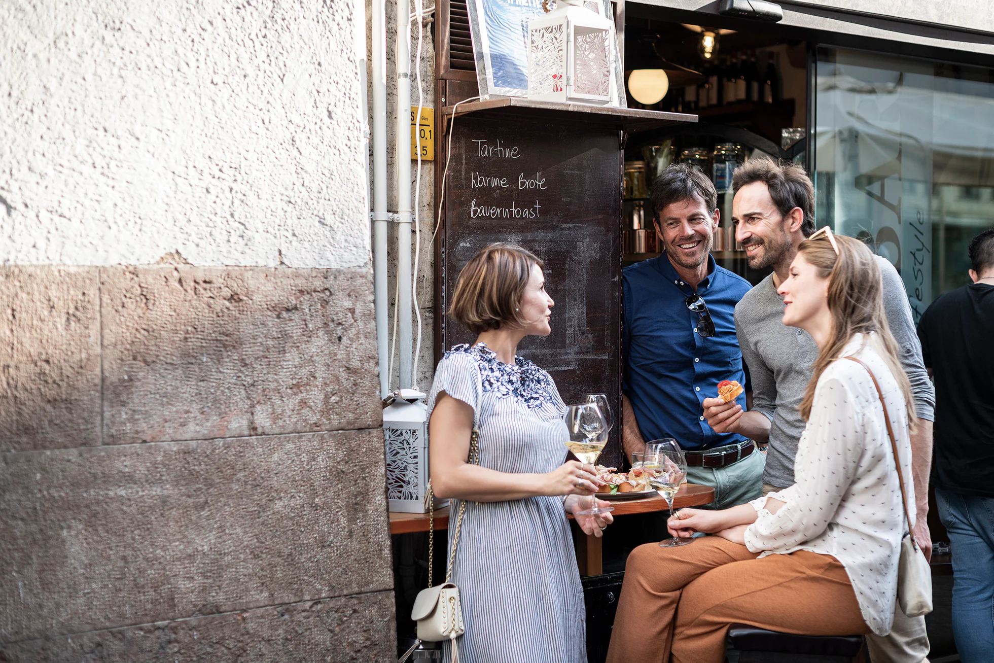 Two women and two men enjoy an aperitif outside in the old town of Bolzano/Bozen.