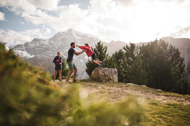 Eine Familie genießt die Zeit in den Bergen beim wandern.