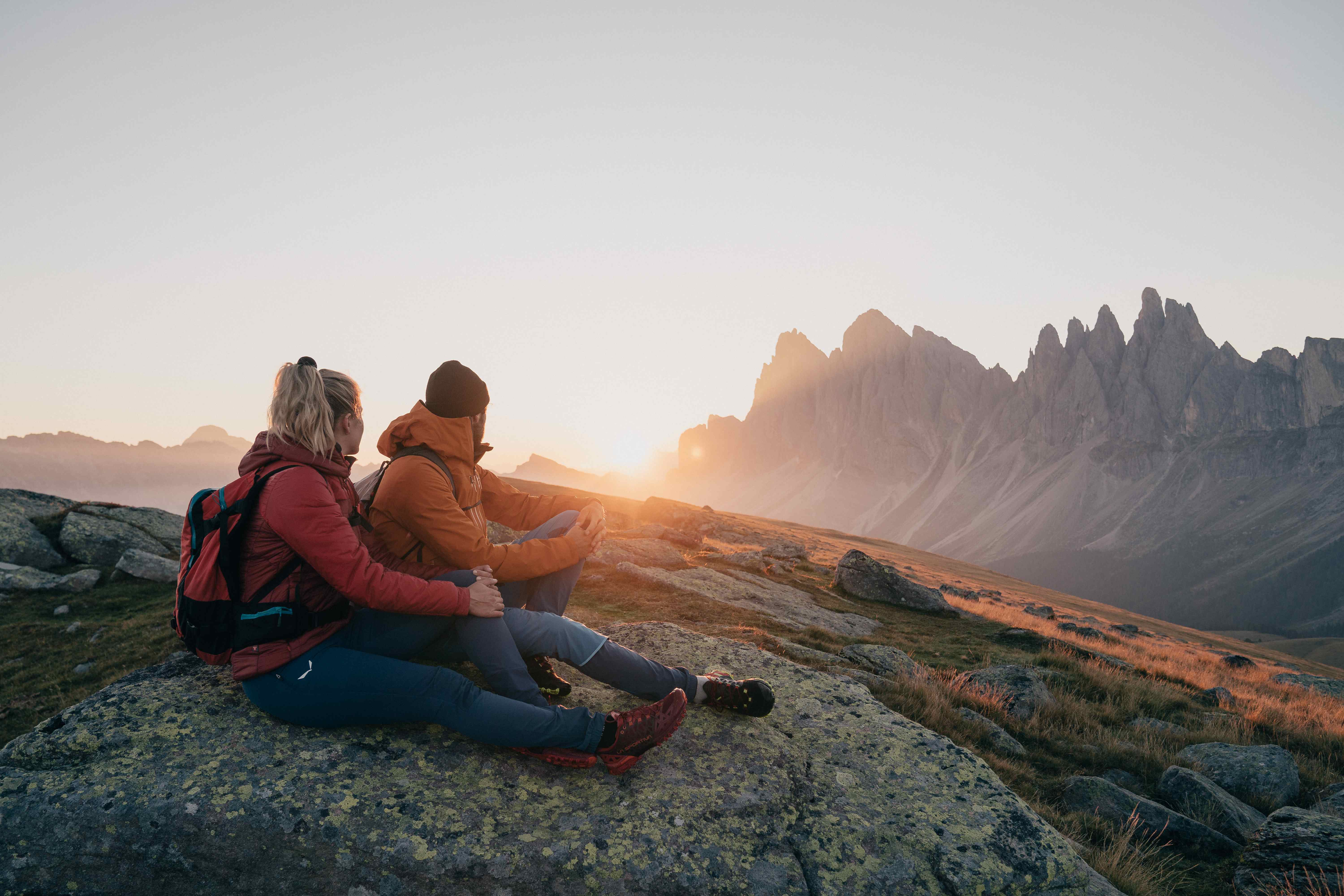 Eine Familie auf einer Wanderung mit einem Gebirge im Hintergrund in der Dolomiten Region Villnösstal
