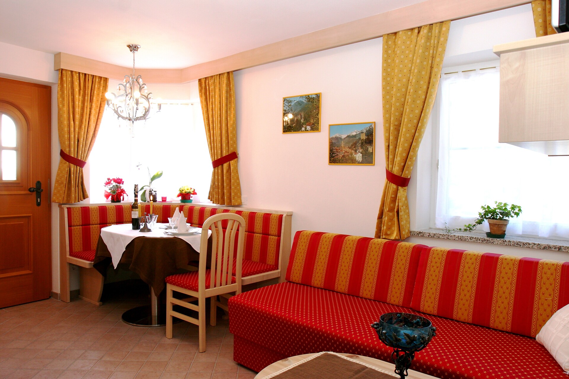 Stilvoll eingerichtetes Wohnzimmer mit voll ausgestatteter Küchenzeile und Platz für ein Zusatzbett.