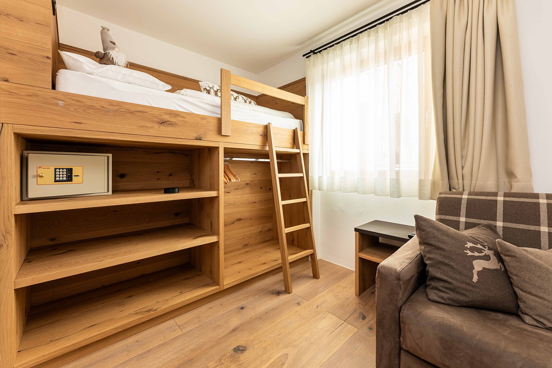 room with high bed and double bed couch
