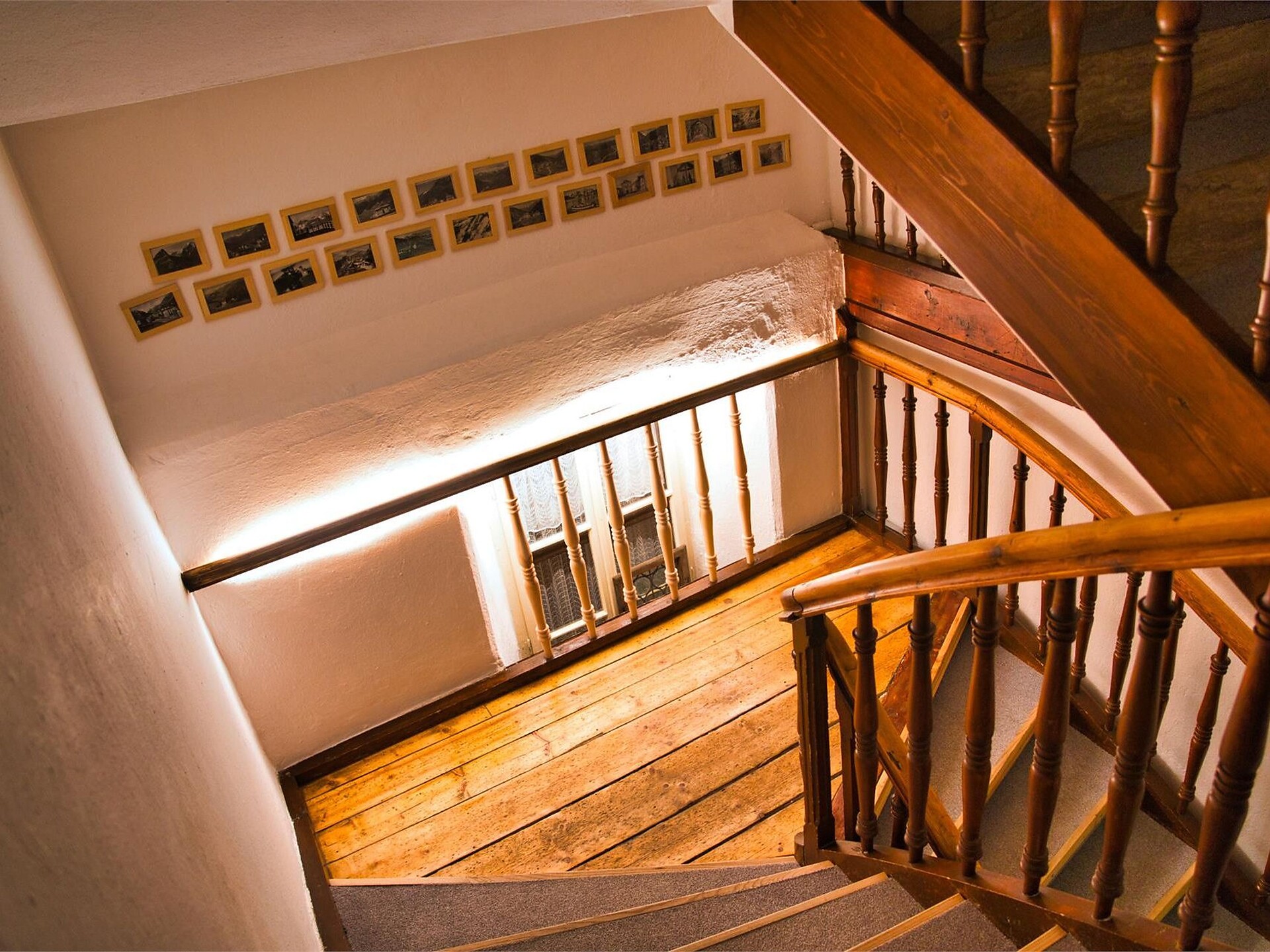 Beleuchtetes Stiegenhaus mit historischen Postkarten