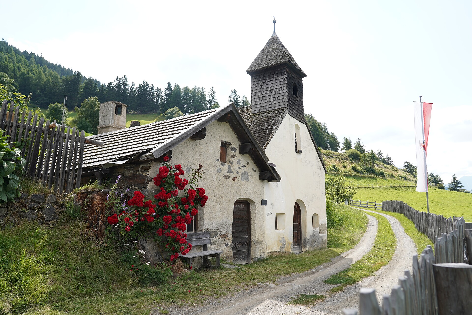Chapel at Lechtlhof with the old farm smithy in summer