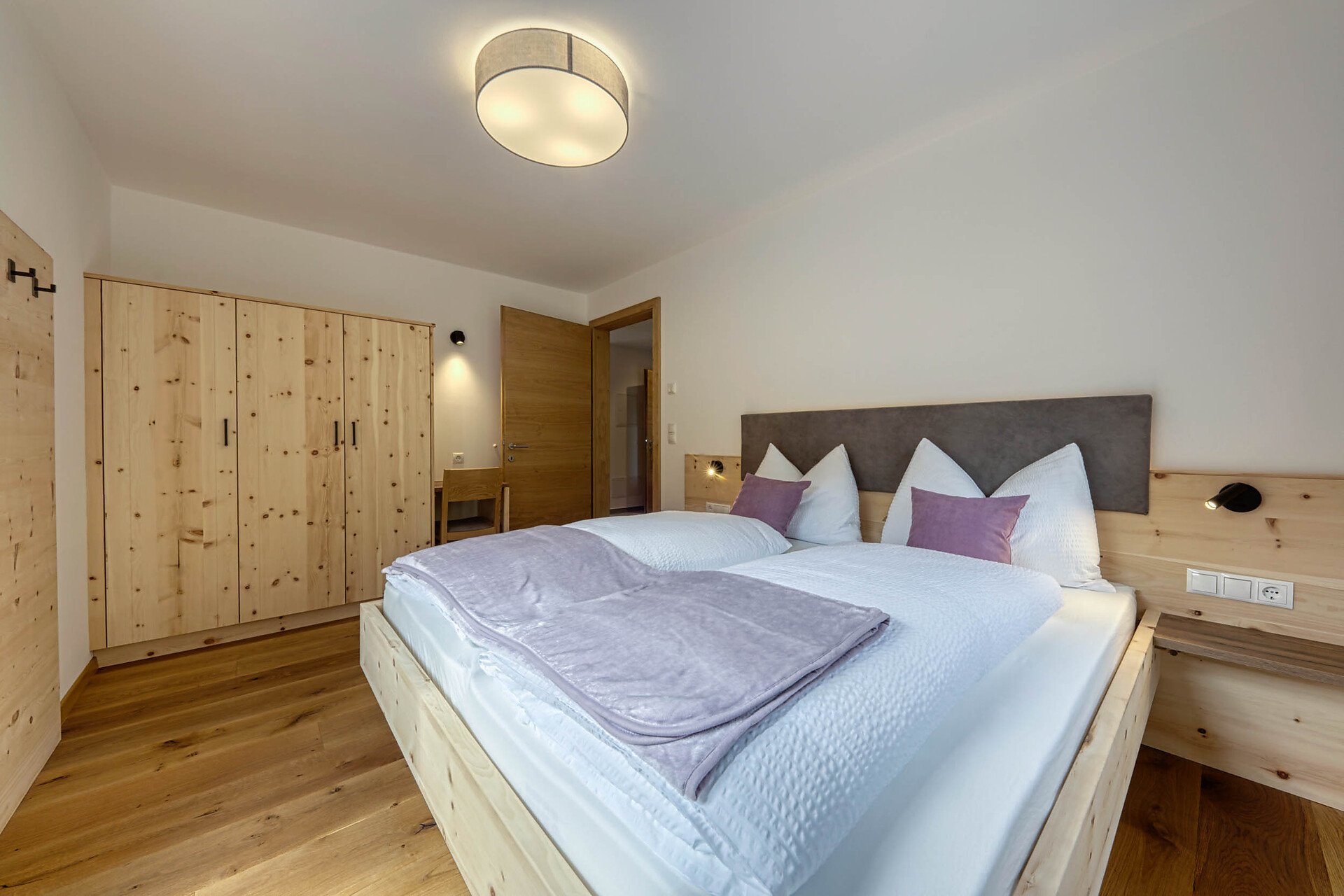 Camera da letto matrimoniale con pavimento in legno, mobili in legno e vista panoramica