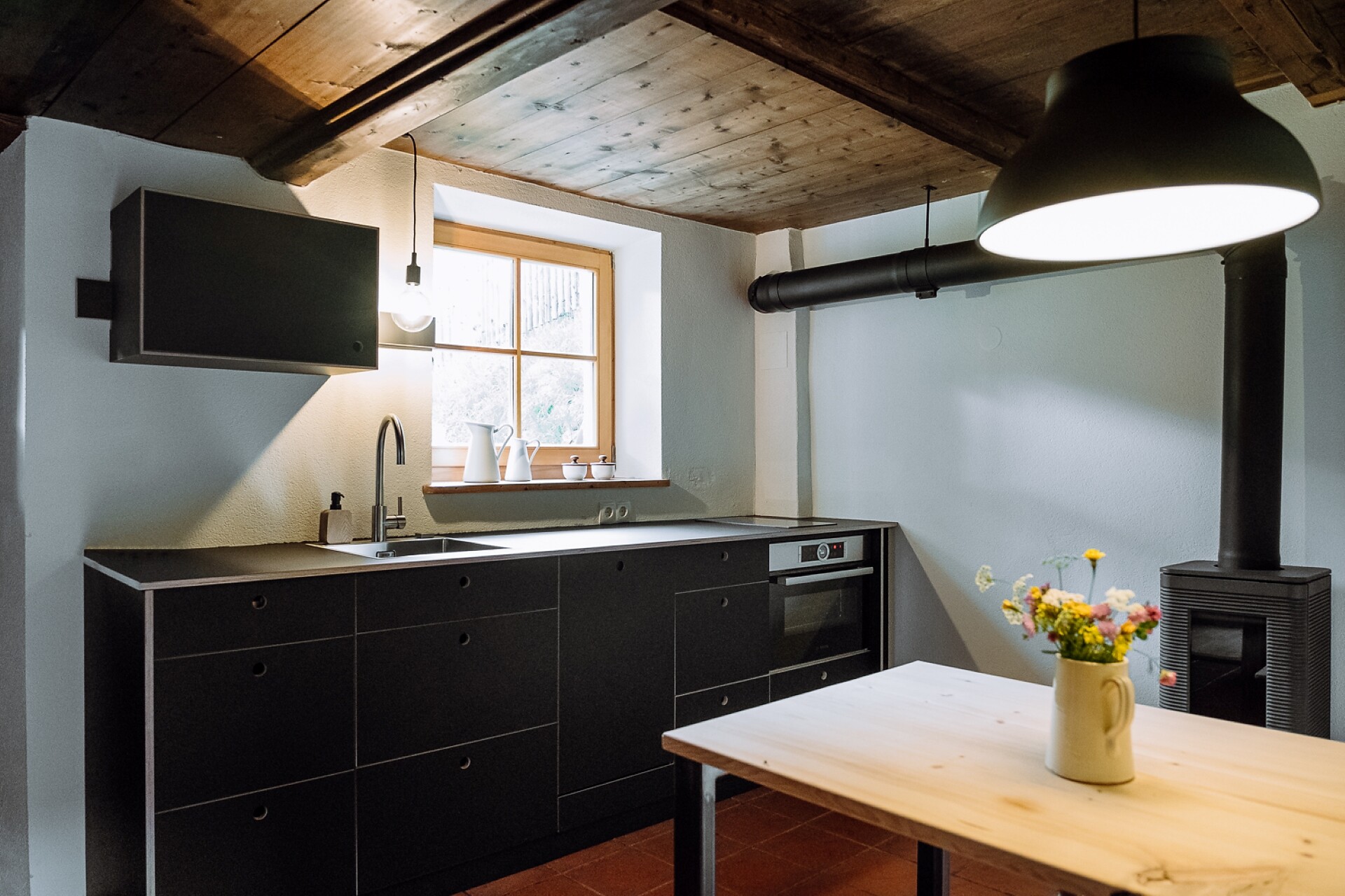 Cucina con piano cottura a induzione e forno a legna