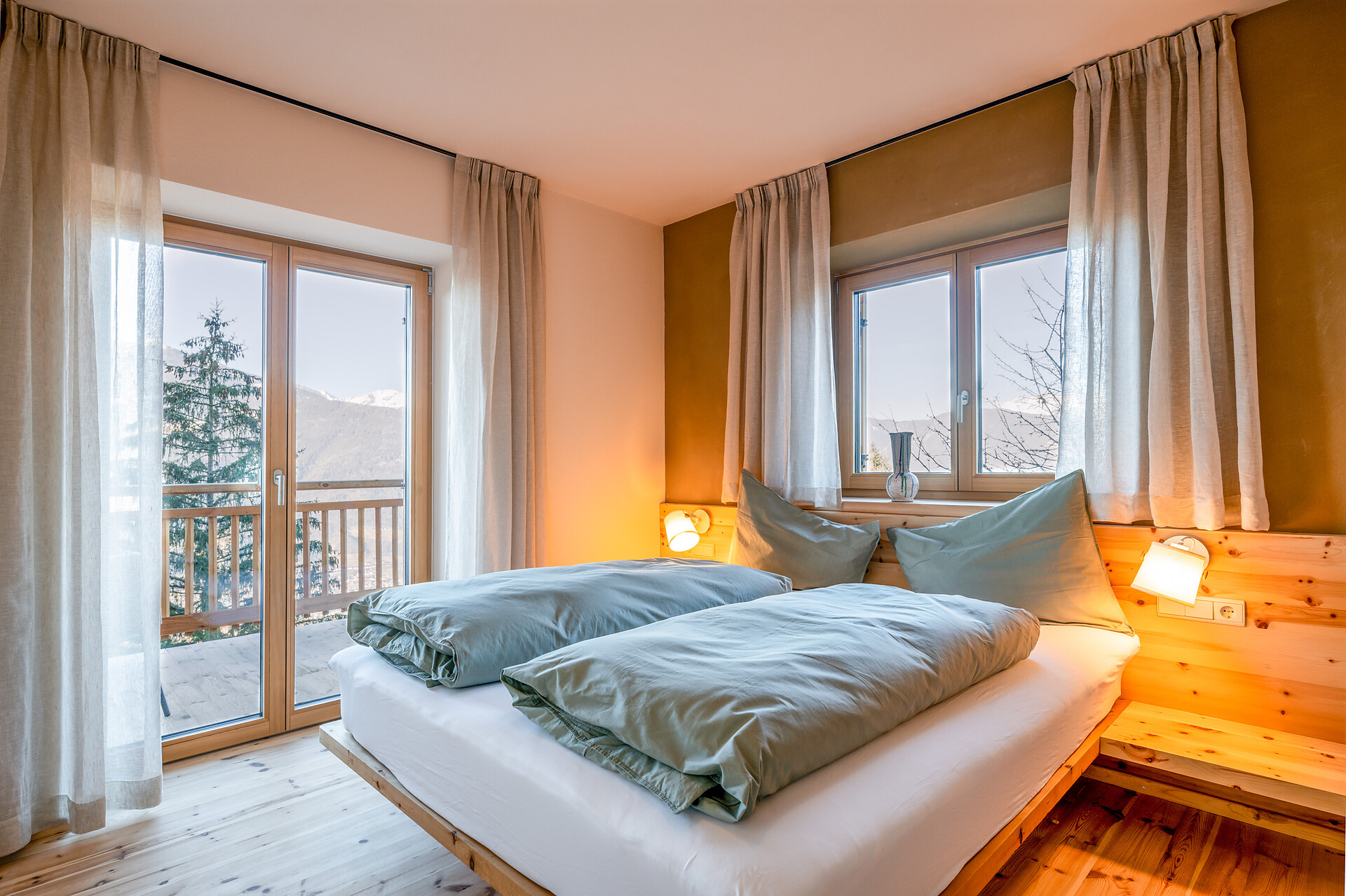 Schlafzimmer mit Lehmwand, Holzboden und Upgecycelte Möbel