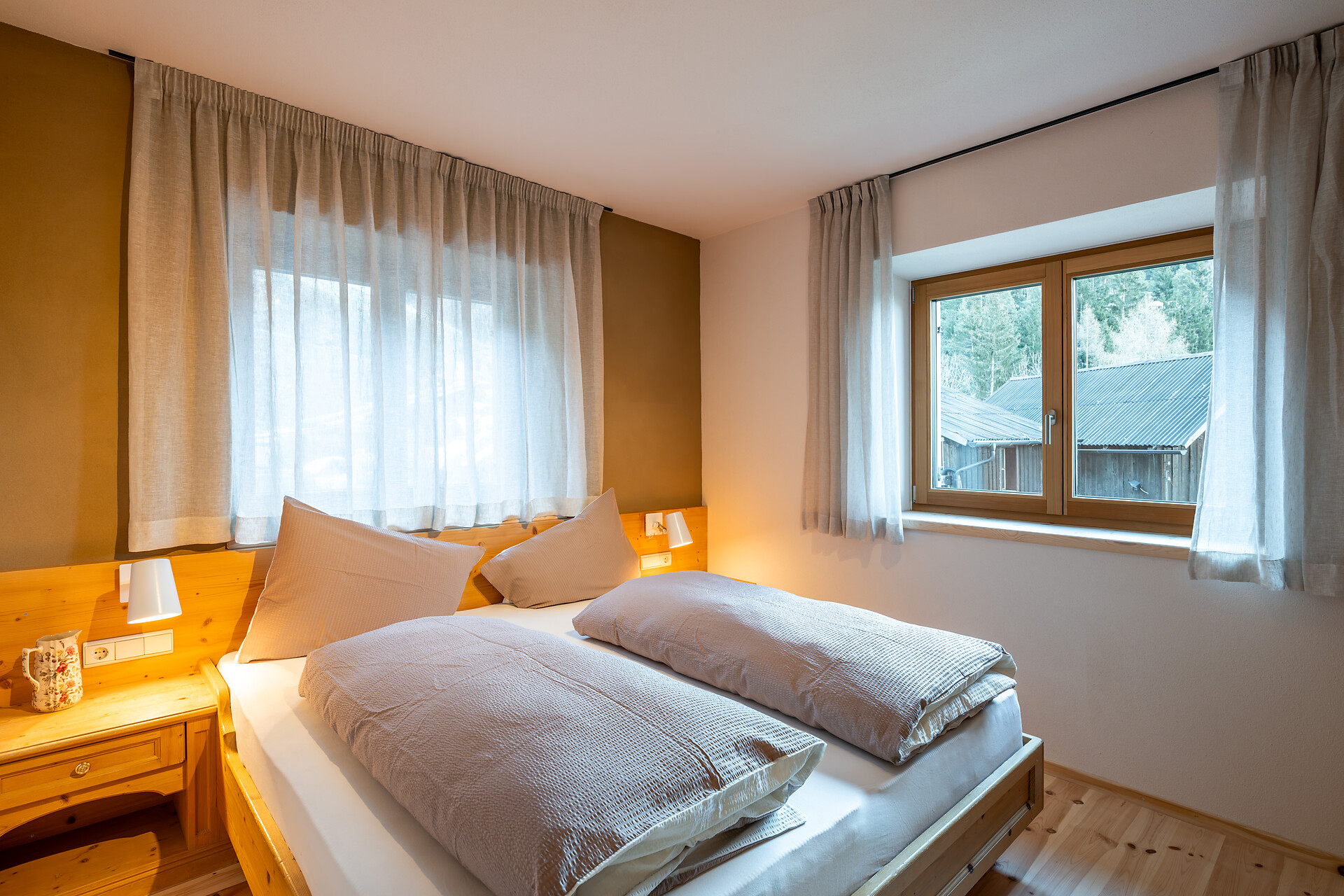 Schlafzimmer mit Lehmwand, Holzboden und Upgecycelte Möbel
