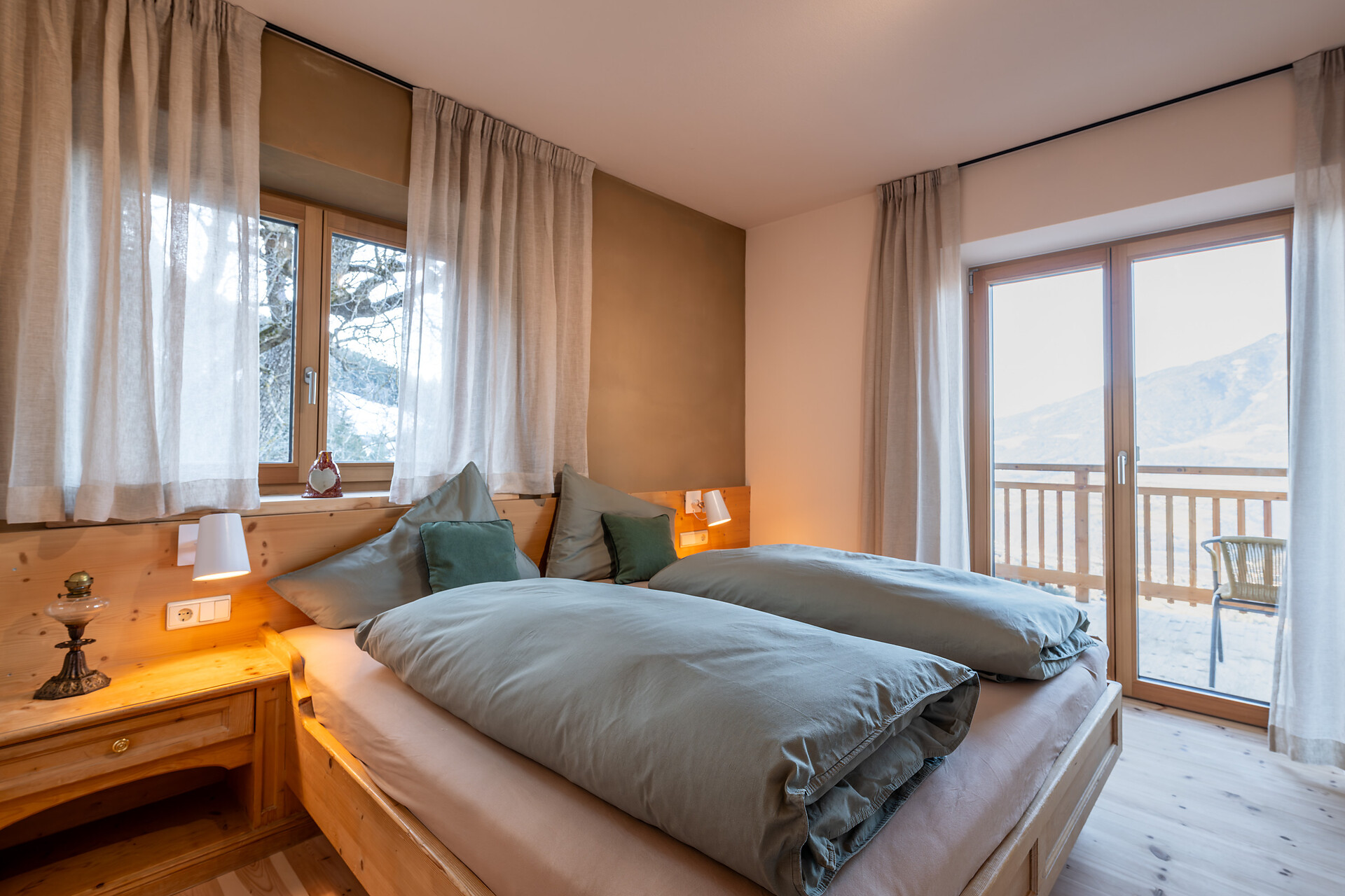 Schlafzimmer mit Lehmwand, Holzboden und Upgecycelte Möbel