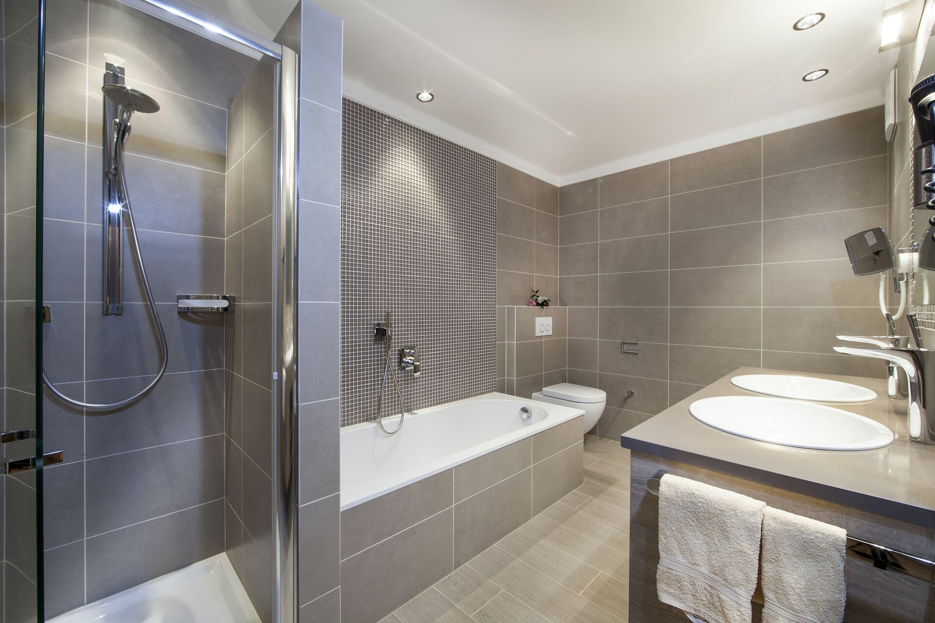 bagno con doccia, vasca e doppi lavandini