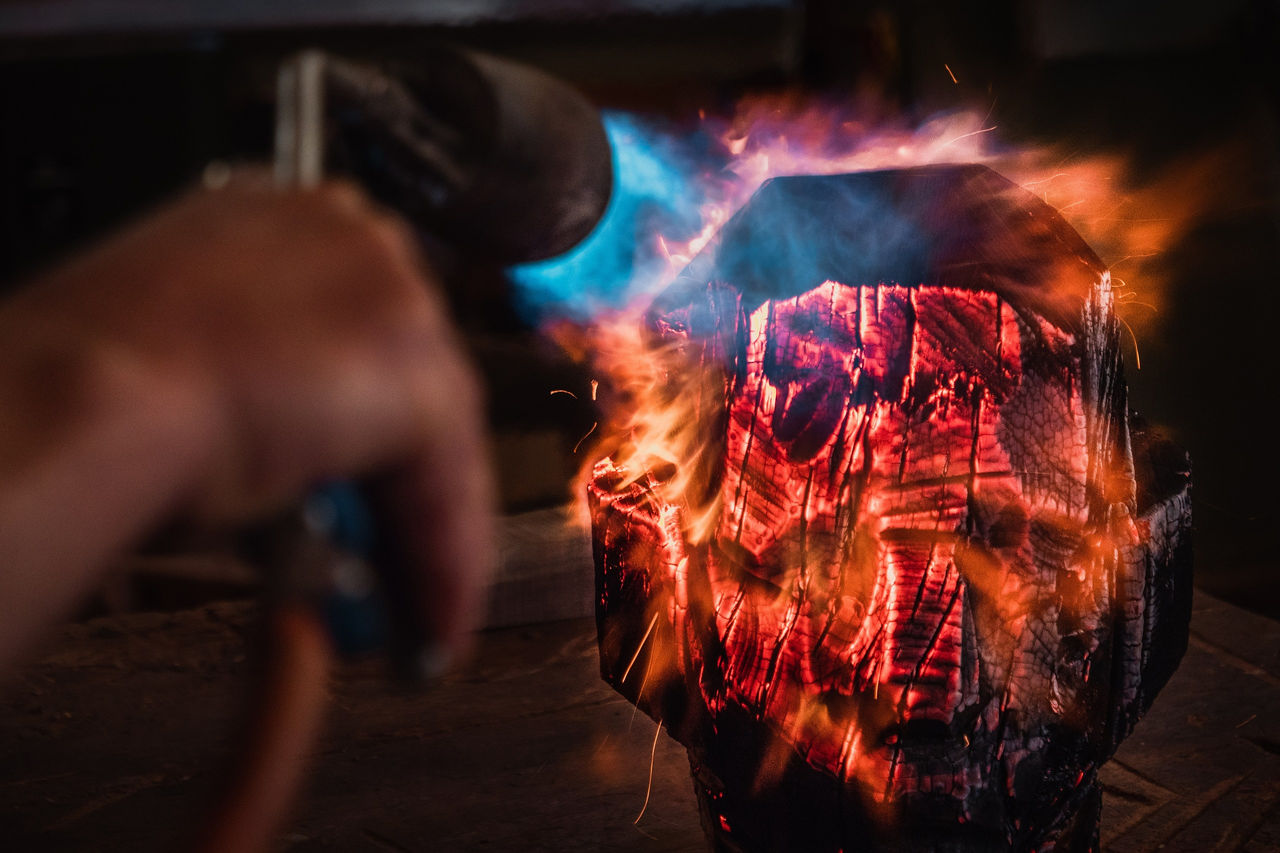 Bildhauer Aron Demetz bearbeitet mit den Flammen eines Anwärmbrenners eine seiner Skulpturen.