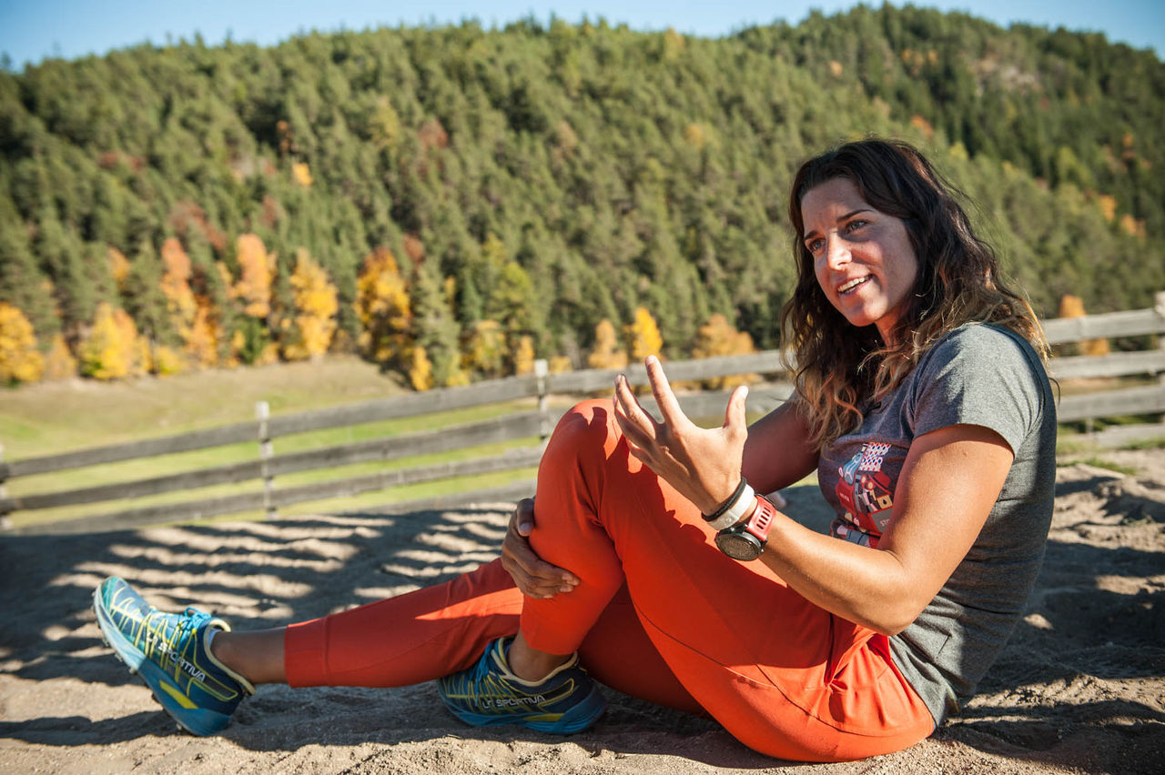 Extrembergsteigerin Tamara Lunger sitzt auf einem Felsen und gestikuliert mit der linken Hand.