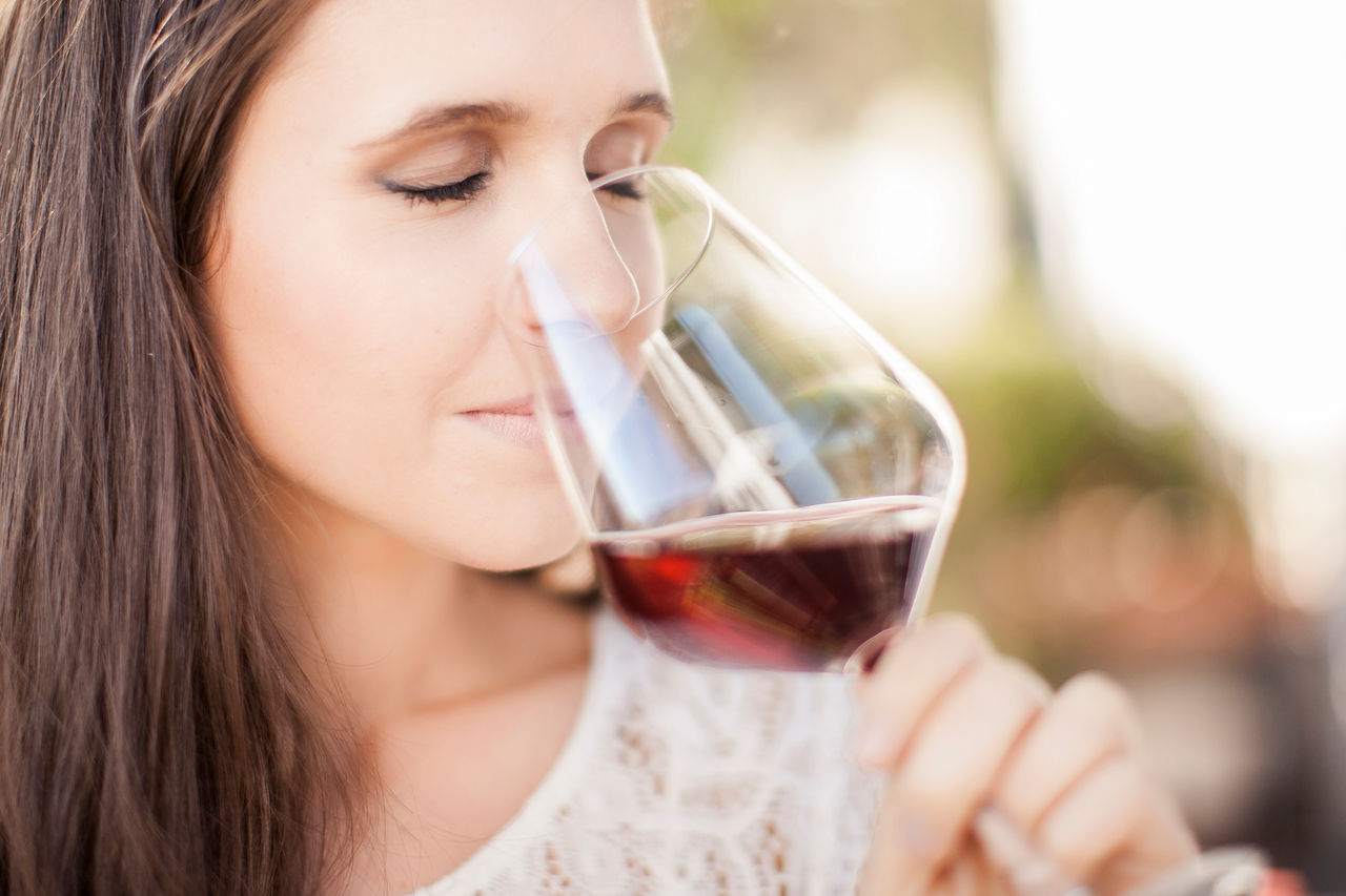 Eine Frau riecht ein einem Glas Rotwein