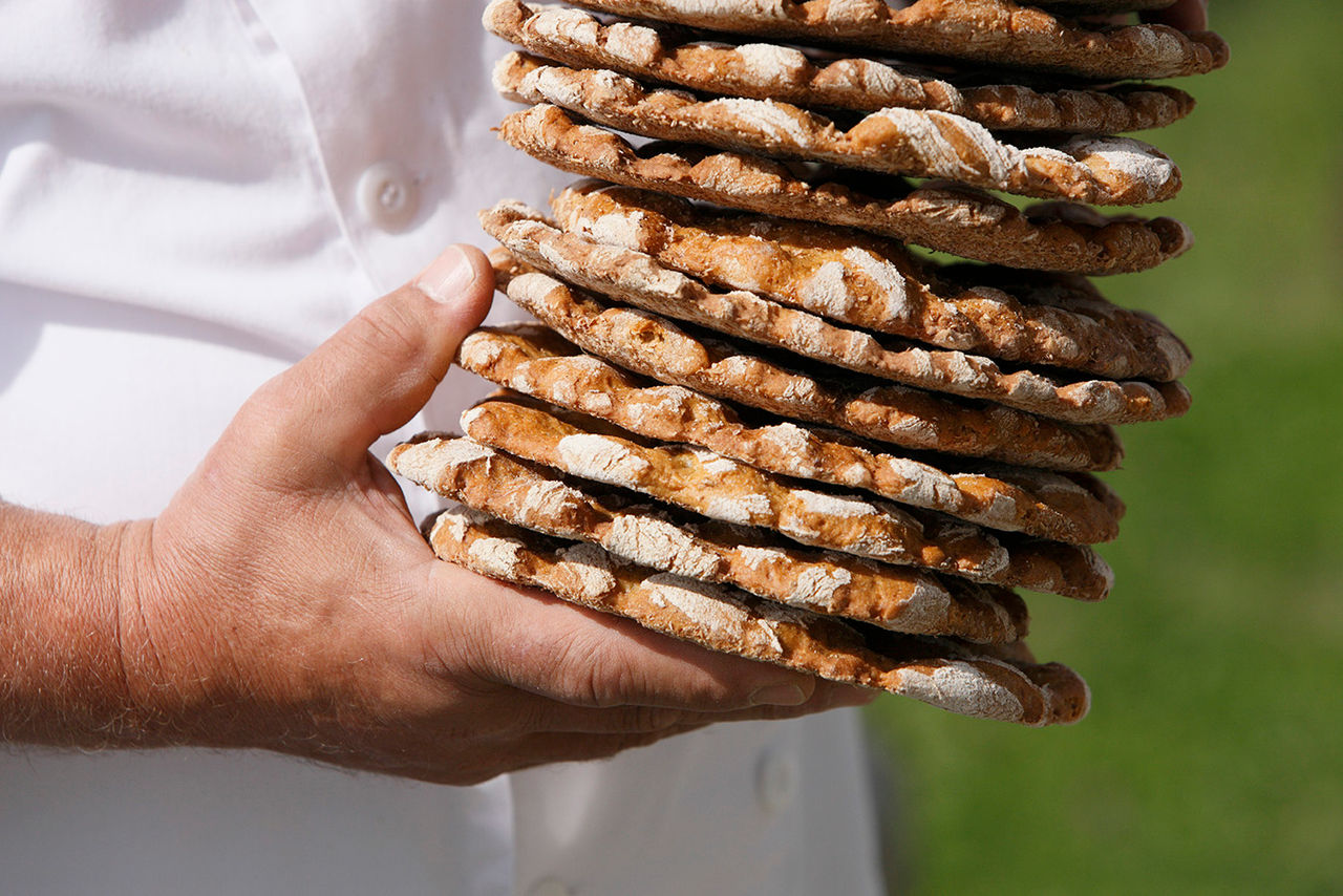 Eine Person hält einen Stappel Südtiroler Schüttelbrot in den Händen