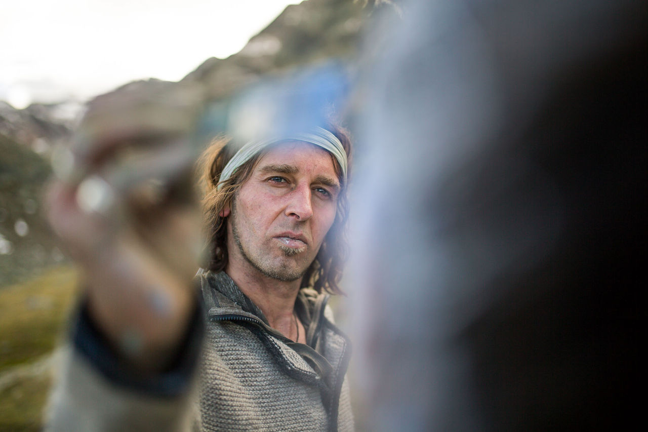 Der Künstler Johannes Stötter malt mit prüfendem Blick den nur in Umrissen sichtbaren Körper einer Frau an.