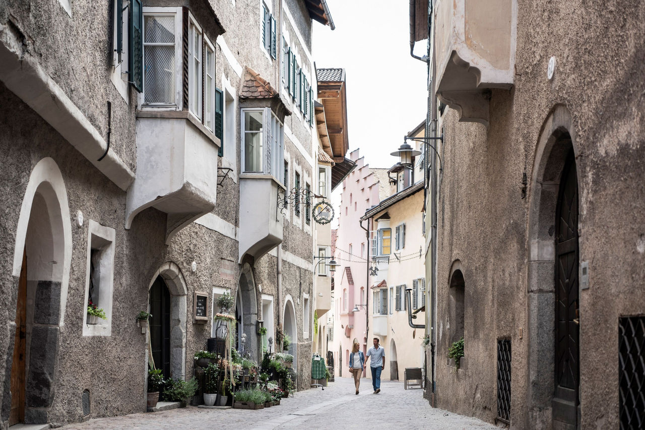 Zwei Personen spazieren durch das historische Zentrum der Altstadt Klausen.