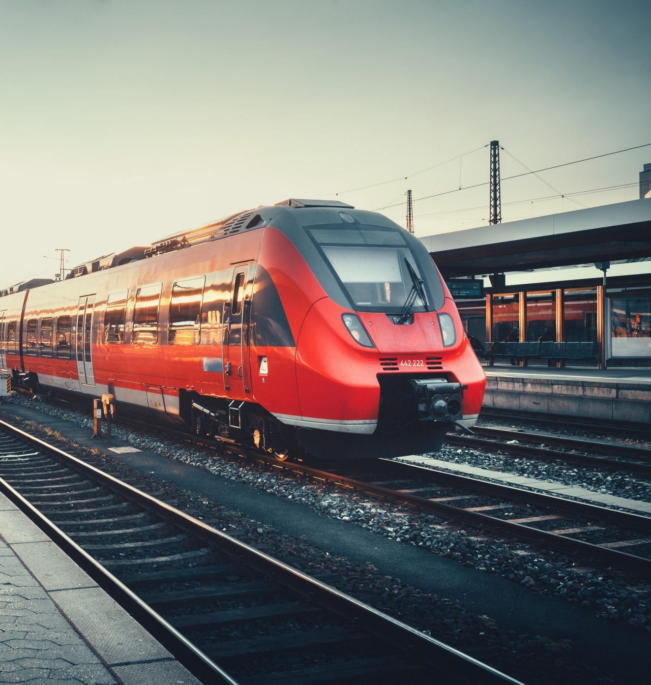 Beautiful railway station with modern red commuter train at colorful sunset in Nuremberg   , Germany. Railroad with vintage toning; Shutterstock ID 428357335; Purchase Order: -