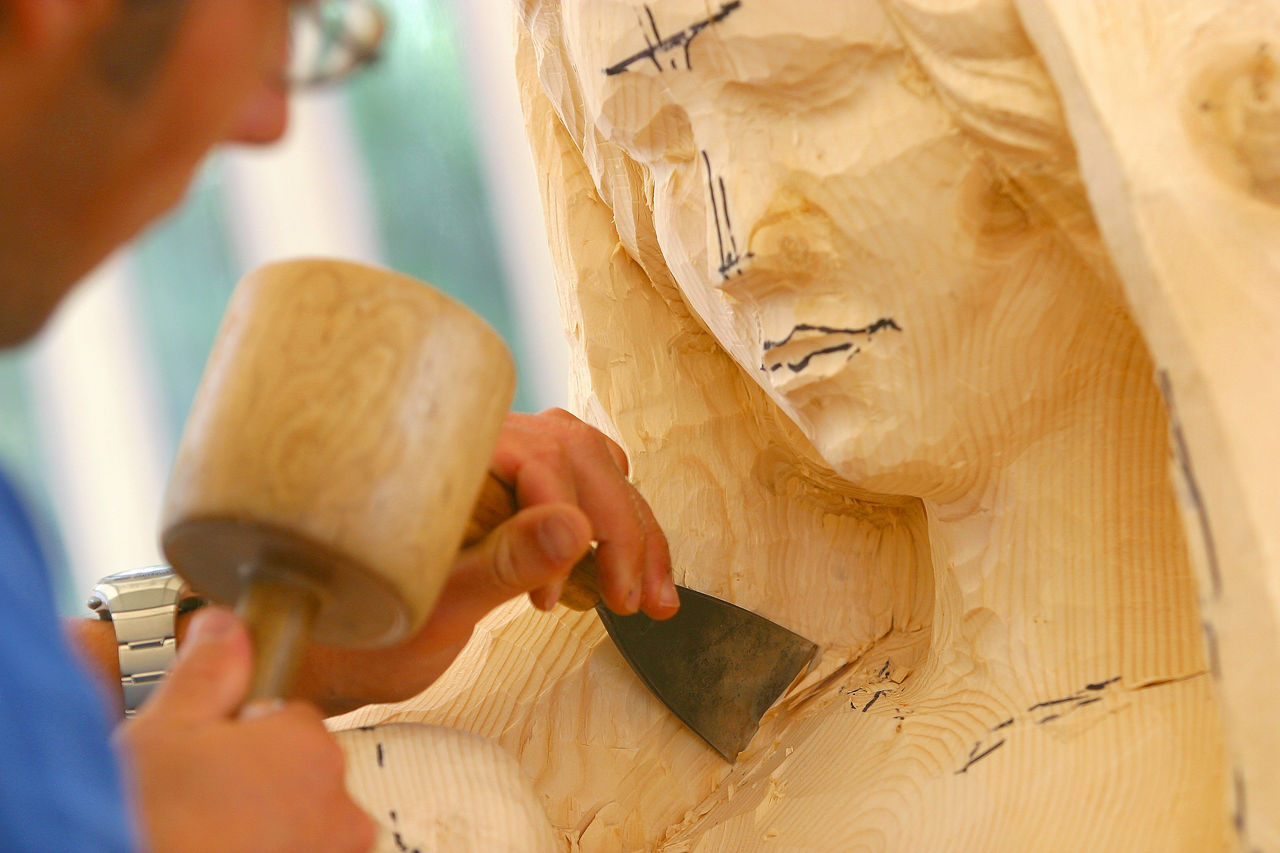 Bildhauer arbeitet an einer Holzskulptur