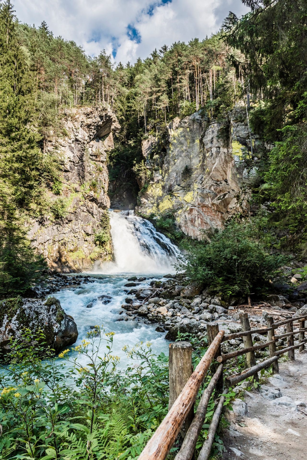 Tosender Wasserfall in alpiner Landschaft mit Aussichtspunkt